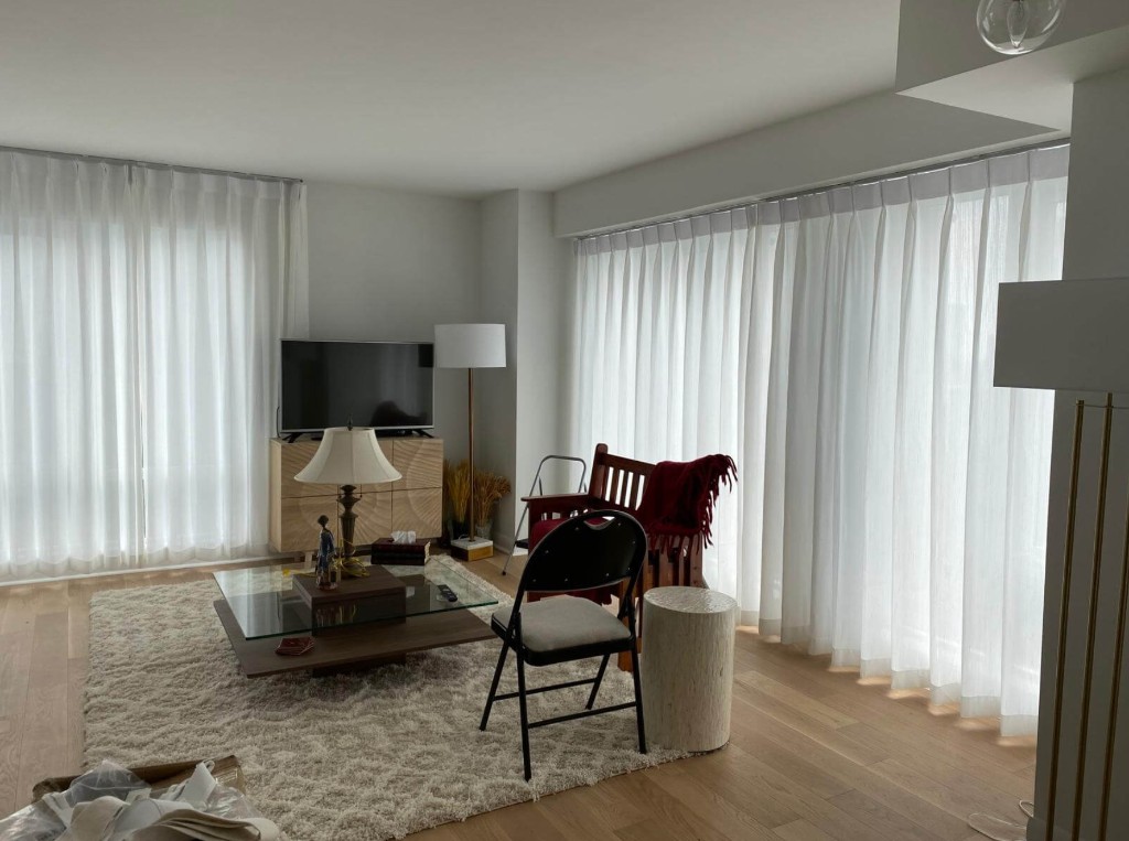 Living room with floor-to-ceiling sheer drapery and modern window treatments